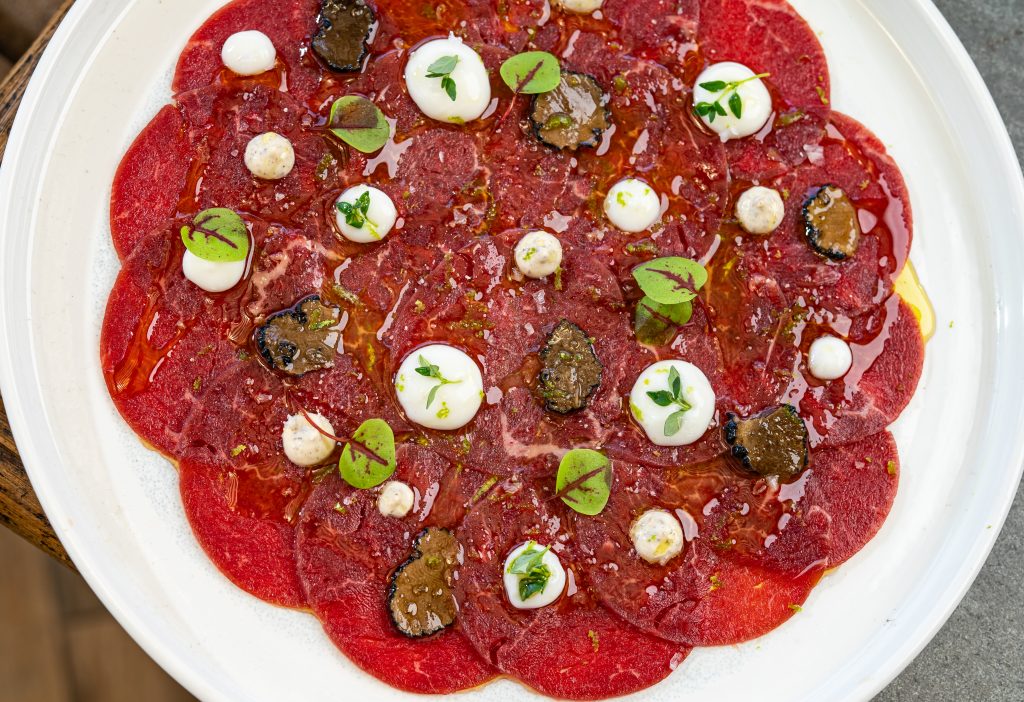 Thin slices of aged beef with smoked cheese, shaved truffle, and carasau bread.
